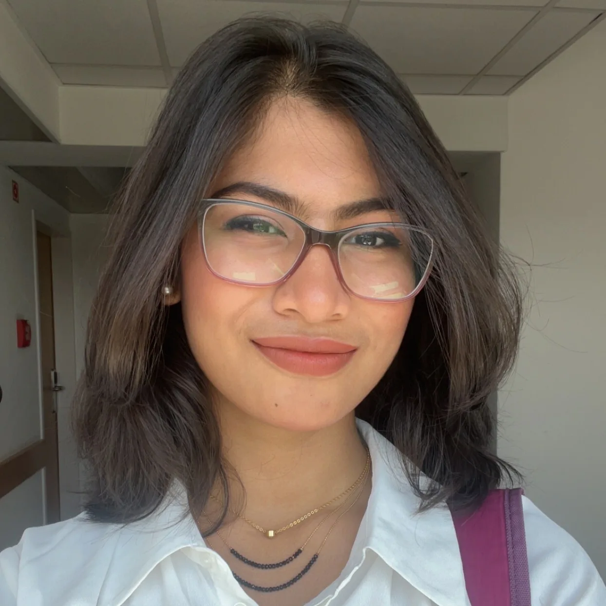 Close-up portrait of Sadia wearing glasses